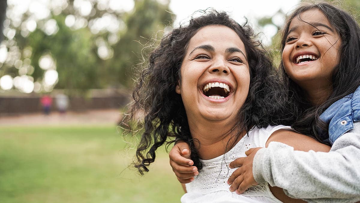 Happy mother having fun with her daughter outdoors