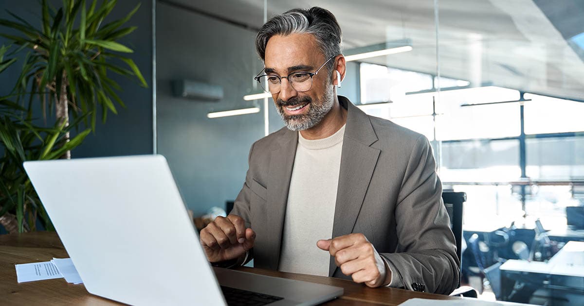 A man looks at documents on his laptop