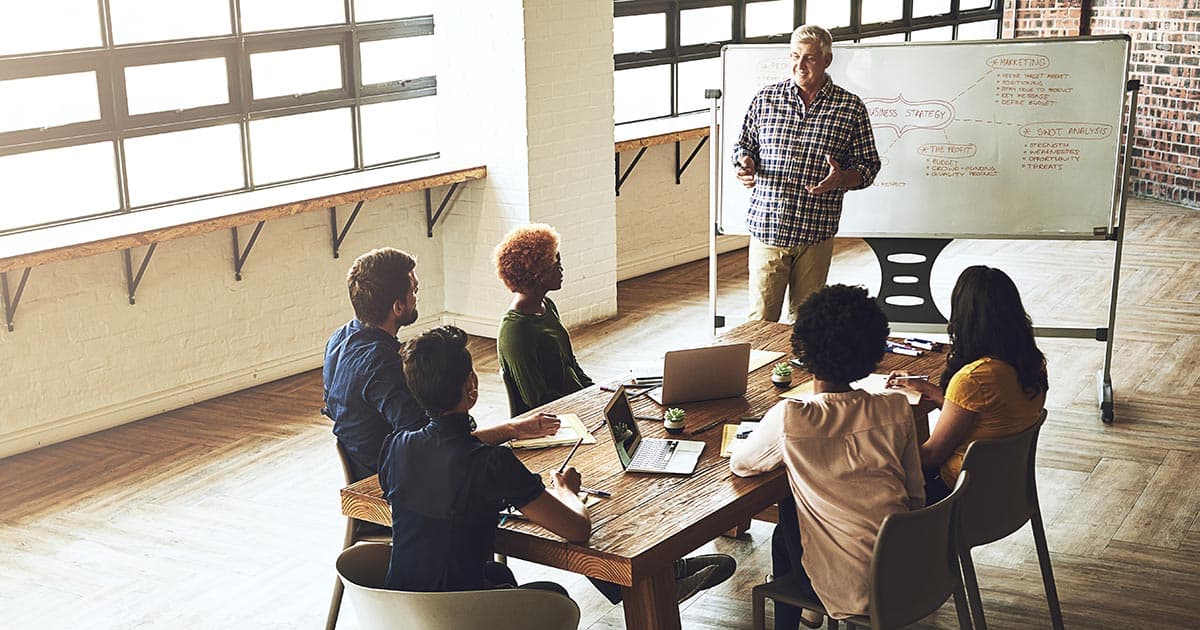 Nonprofit board and leadership team meeting around a conference table discussing governance, financial reporting, and Form 990 transparency initiatives.