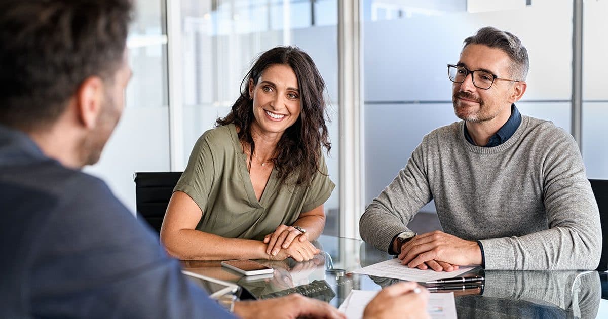Man and woman meet with a financial advisor to start investing in 2024