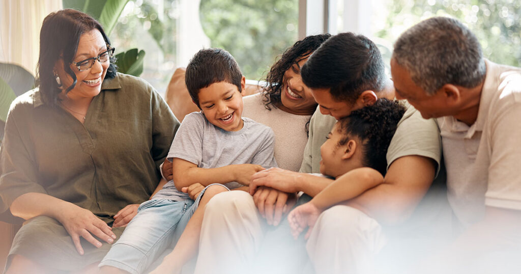 Multigenerational family sitting on a couch and smiling.