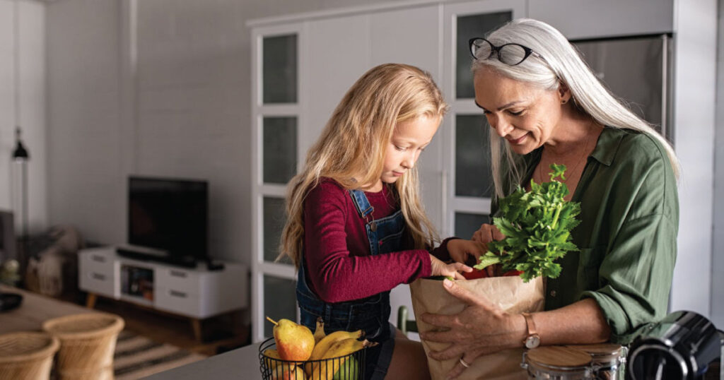 Woman with granddaughter with groceries