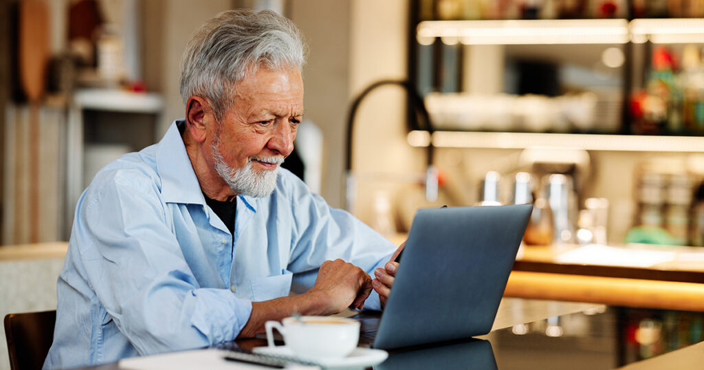 Older man researching on laptop