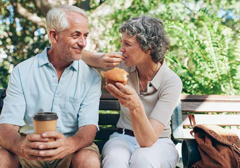 Loving senior couple sitting on a park bench.
