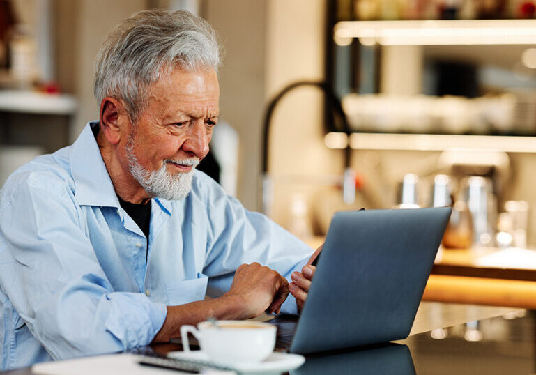 Older man researching on laptop