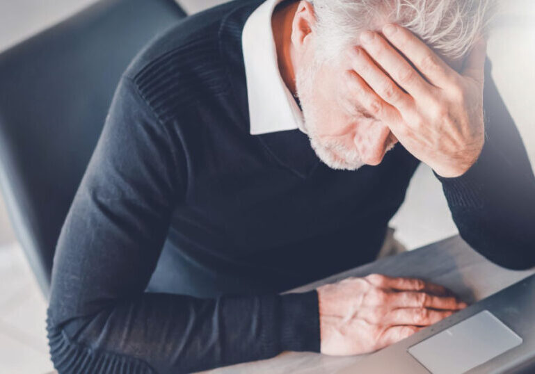 Frustrated man sitting in front of laptop