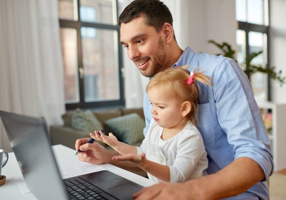 multi-tasking, freelance and fatherhood concept - working father with baby daughter and laptop computer at home office