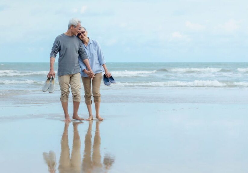 Couple walking barefoot on beach