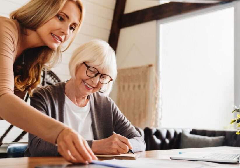 Mother and daughter looking through documents in front of laptop