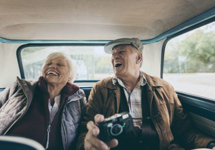 Senior couple in back of taxi traveling abroad