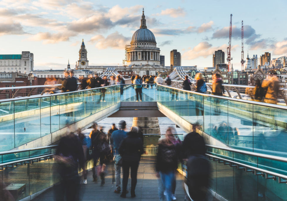 London and St Paul Cathedral at sunset, with blurred people walking on the bridge. Long exposure image with crowd visiting London. Travel, tourism and architecture concepts