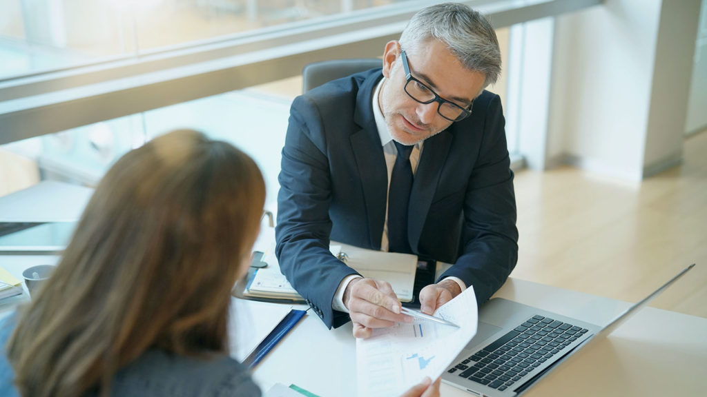 Well-dressed people review charts and graphs in an office
