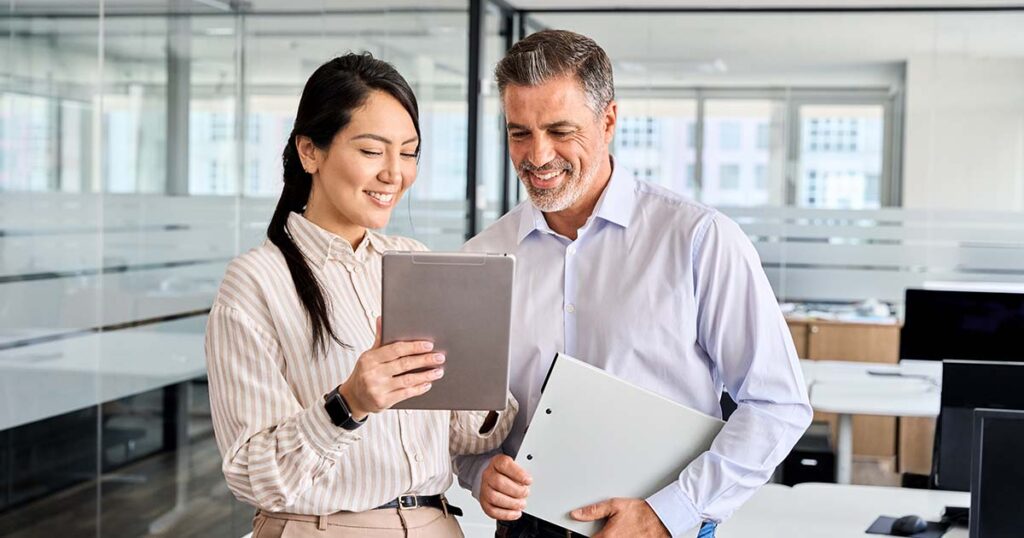 Coworkers discussing internal control policies over tablet