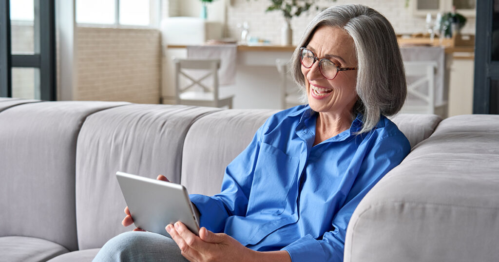 senior aged woman enjoys her iPad