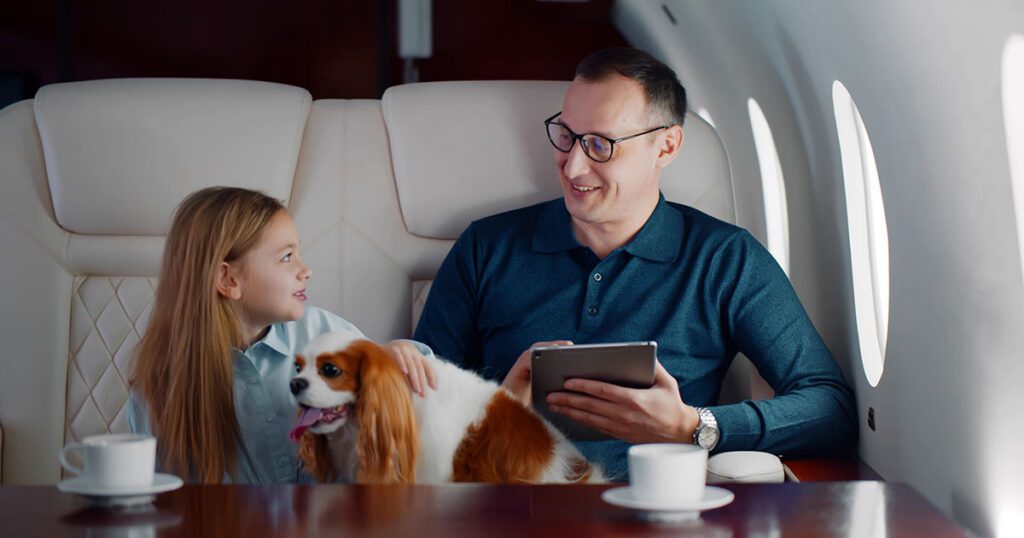 Wealthy father and daughter traveling together on a private jet with their dog, representing the lifestyle and multigenerational wealth management needs of a high-net-worth family