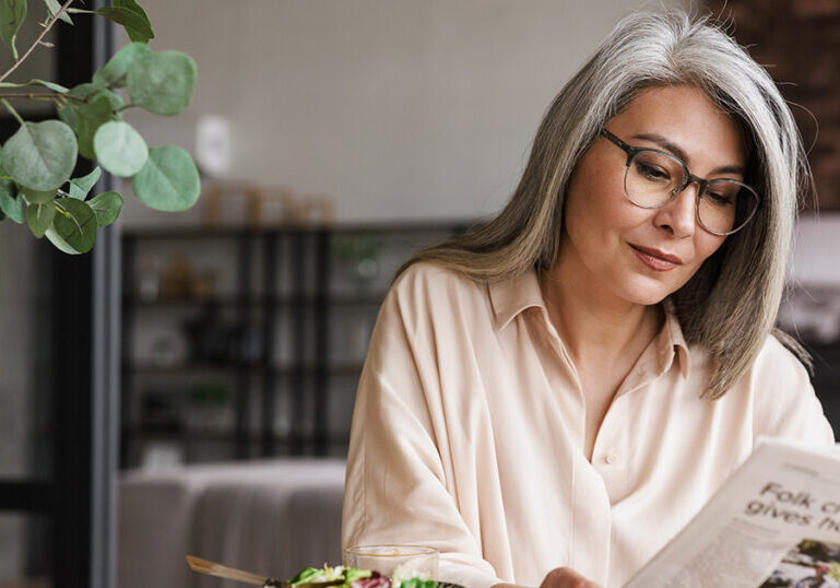 Woman reads about market volatility in newspaper
