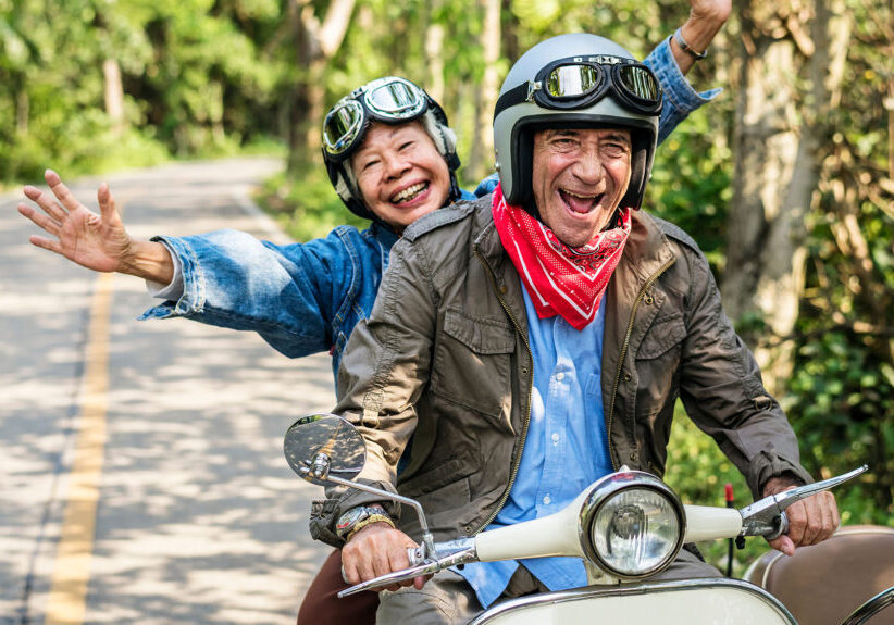 Senior couple having a blast riding a classic scooter