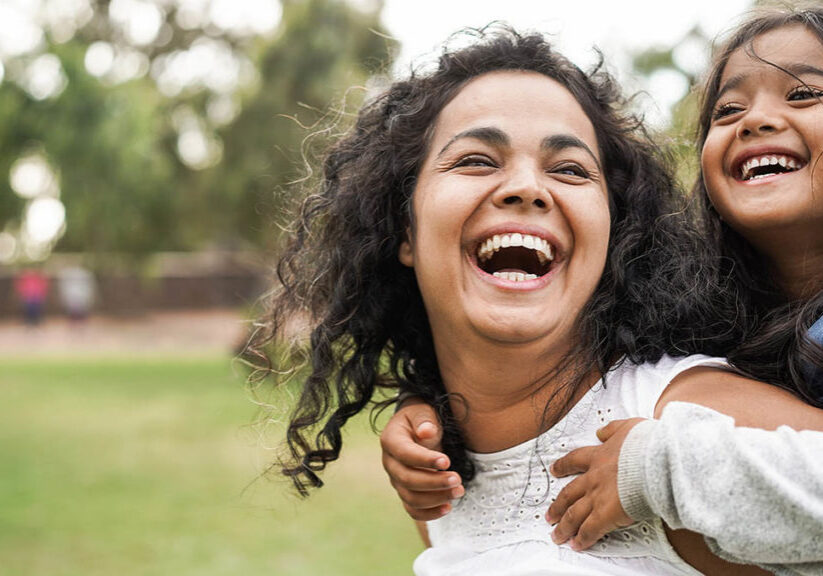 Happy mother having fun with her daughter outdoors
