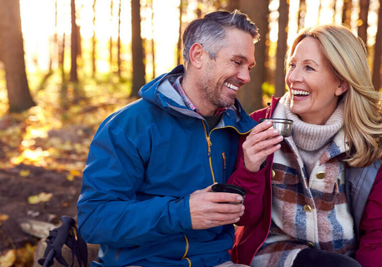 Mature Retired Couple Stop For Rest And Hot Drink On Walk Through Fall Or Winter Countryside