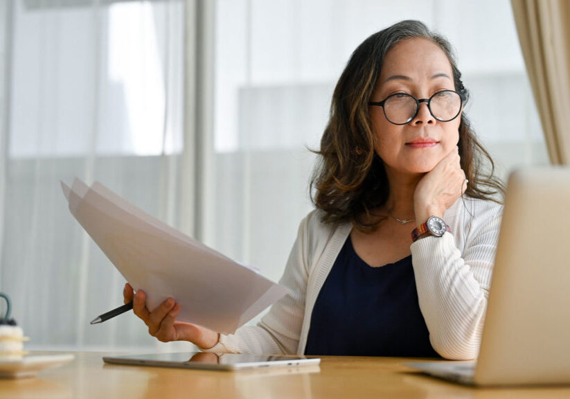 Concentrating middle-aged female using portable computer