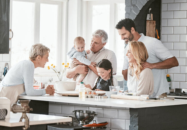 Multigenerational family spending time together in a kitchen, symbolizing tax-efficient wealth transfer across generations