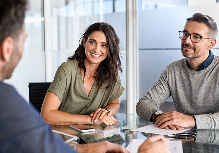 Man and woman meet with a financial advisor to start investing in 2024