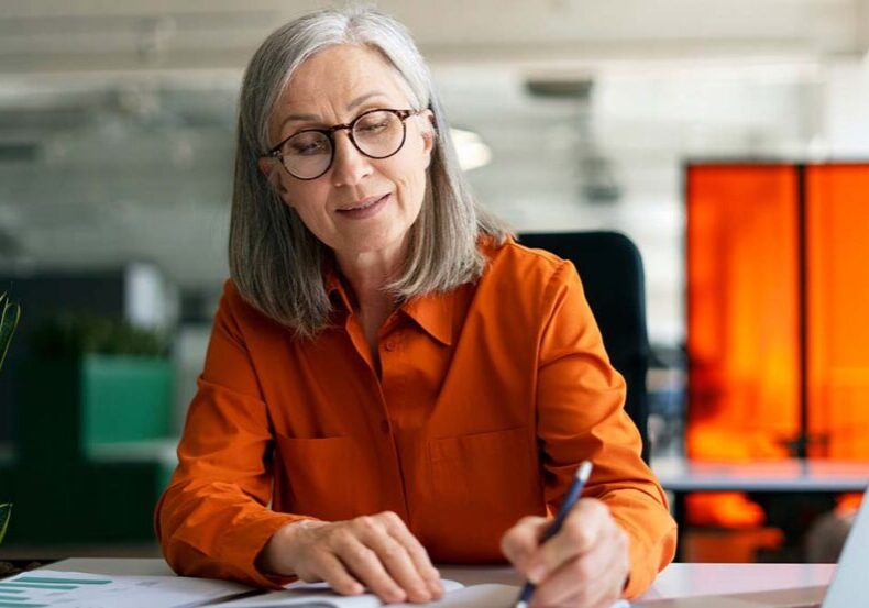 Confident mature woman, writer  using laptop computer, taking no