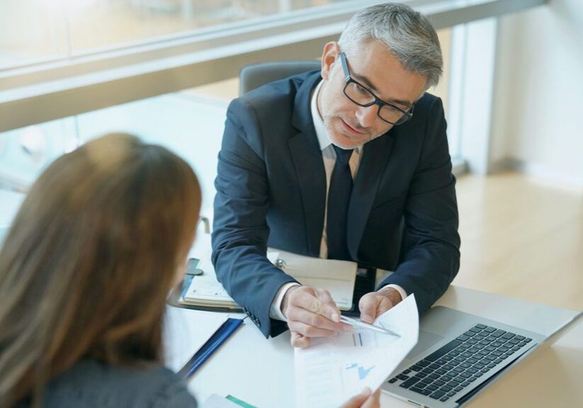 Well-dressed people review charts and graphs in an office