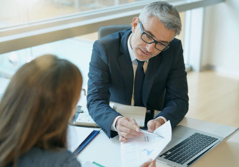 Well-dressed people review charts and graphs in an office