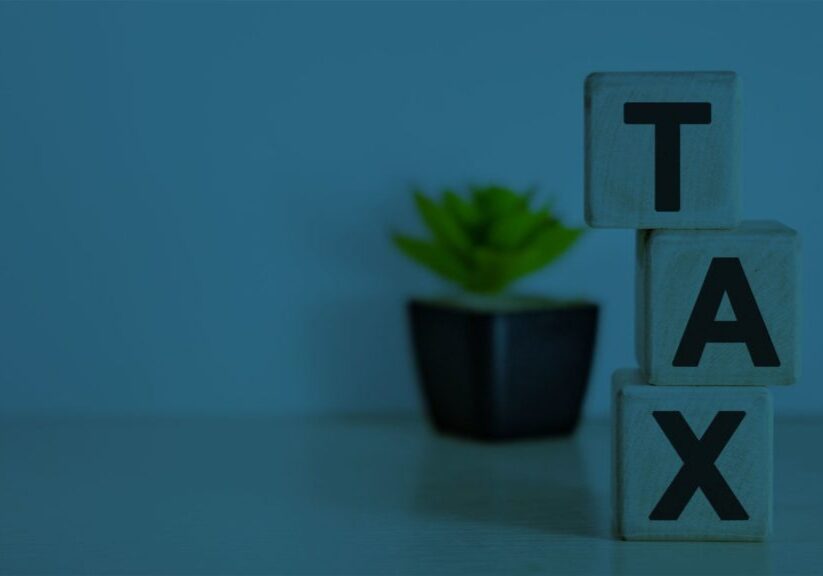 Wooden blocks with letters spelling TAX