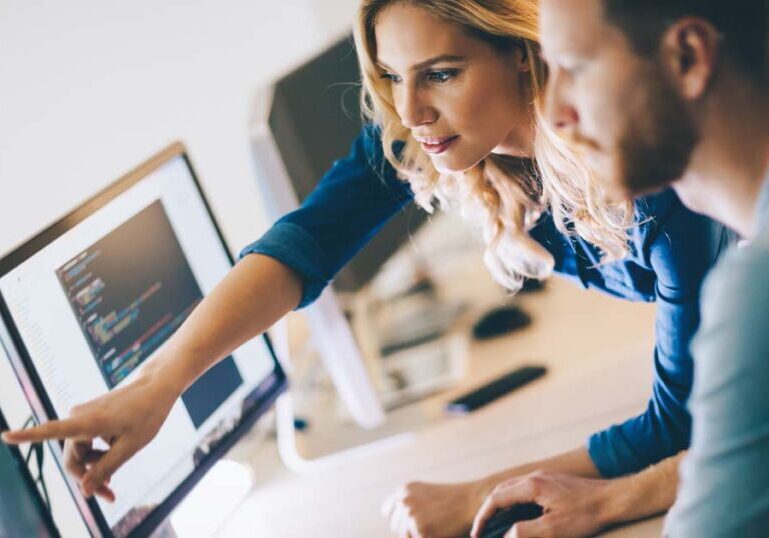 Coworkers discussing data over a computer