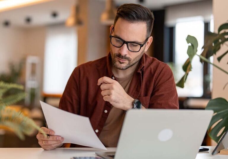 business owner analyzing tax documents at his desk