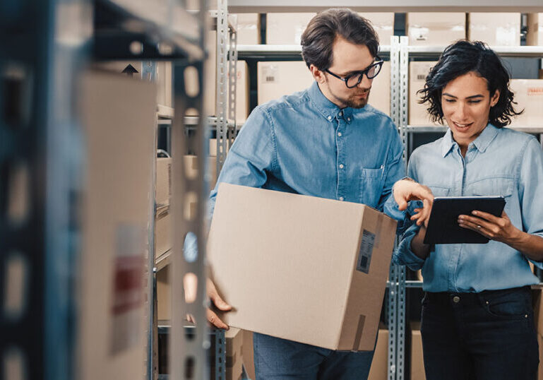 People in warehouse reviewing ERP software.