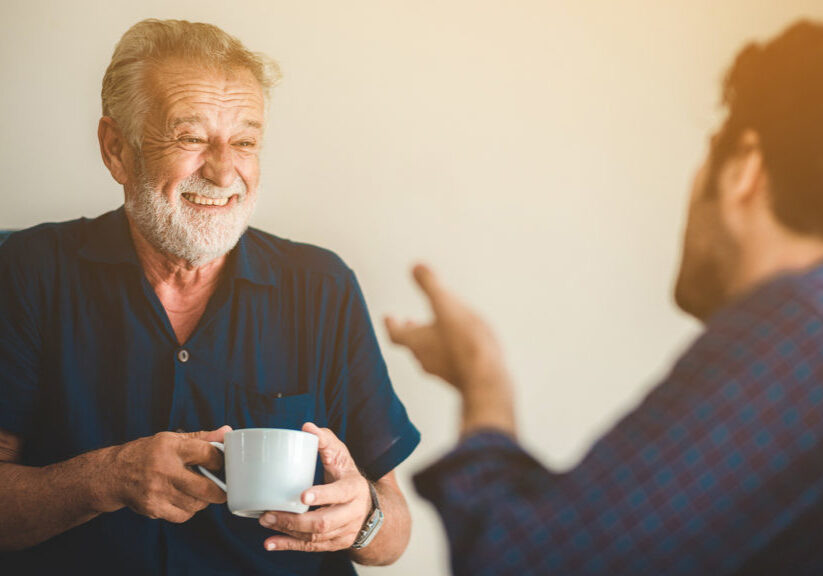 An adult hipster son and senior father talking about at home, family living at home in the morning with coffee cafe