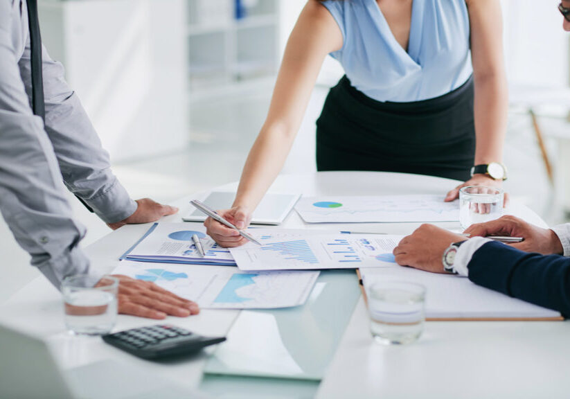 Cropped image of business people discussing papers on table