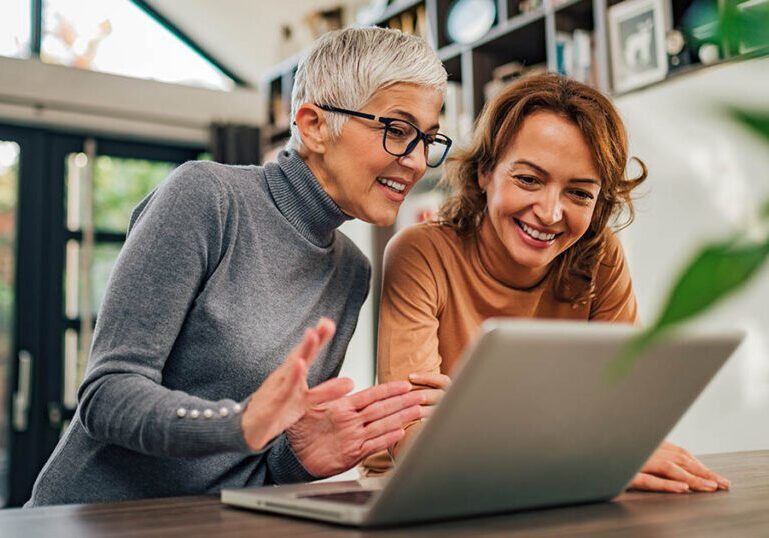 A mother and daughter working on a laptop