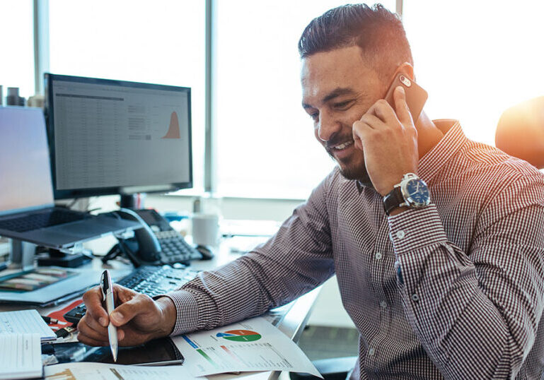 Outsourced accountant on phone with client discussing financials