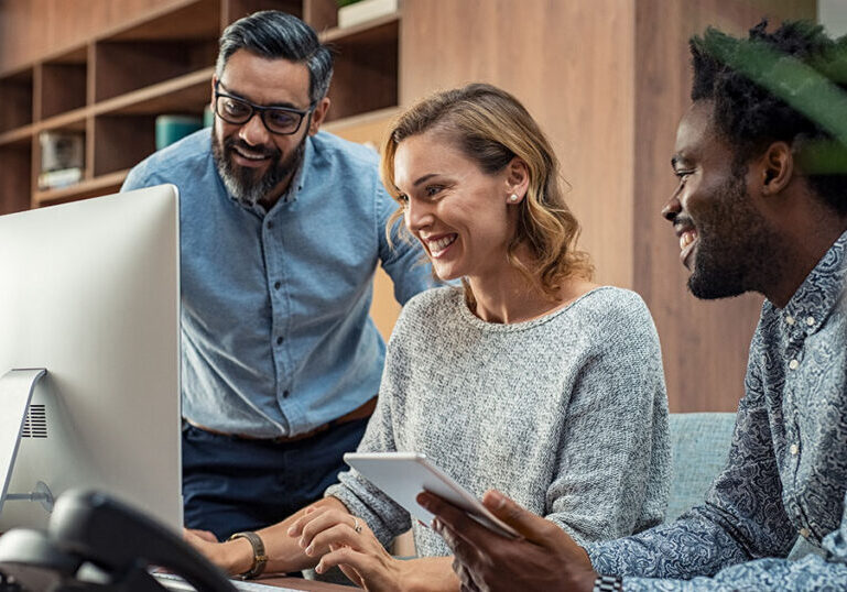 Business team reviewing data on computer and tablet