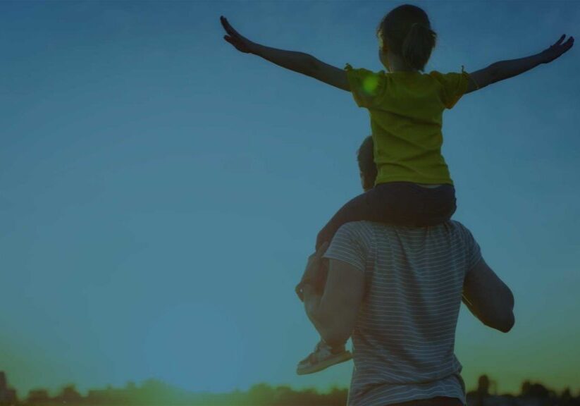 Man holding child on shoulders