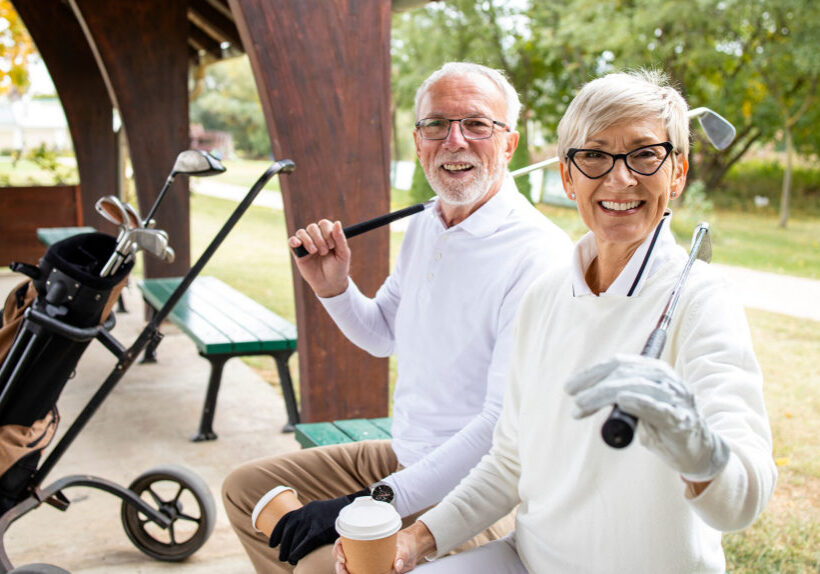 Portrait of senior people in retirement holding golf clubs and ready for golf training.