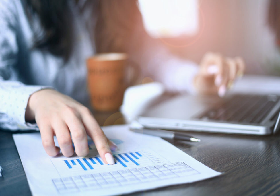 Hands of financial manager taking notes when working