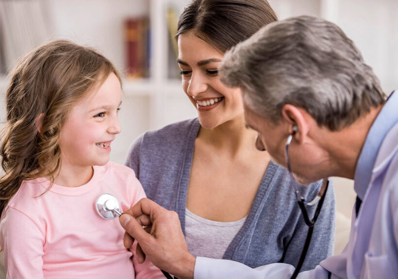 Pediatrician checks breath stethoscope a little girl in the arms of mother.