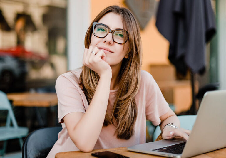 millennial woman with laptop sitting in cafe